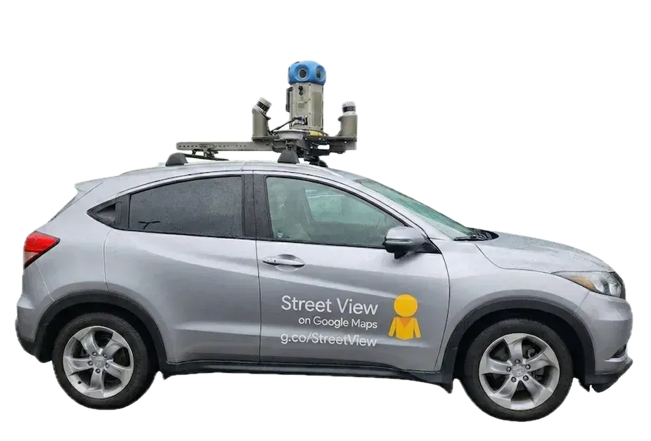 Googleのストリートビュー撮影車。車の屋根に360度カメラを載せた銀色のSUVで、車体に「Street View on Google Maps」と書かれている